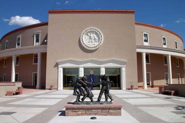 The New Mexico State Capitol (1966, W.C. Kruger) in Santa Fe, NM, nicknamed the Roundhouse. The state seal is over each of the four entrances. Viewed from above, the building was designed to resemble the Zia Sun Symbol, from the NM state flag.